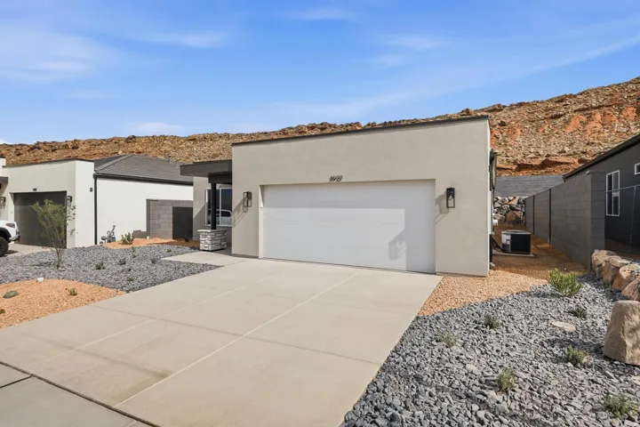 Contemporary stucco exterior with a flat roofline, integrated garage, and a concrete driveway