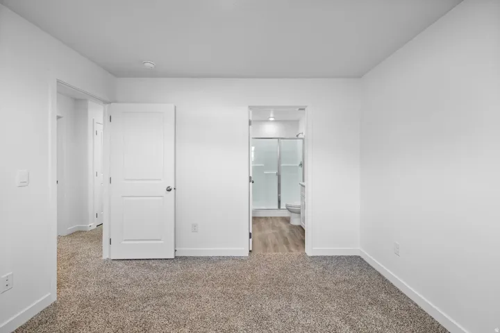Plush carpet flooring, white painted walls, and a recessed ceiling light