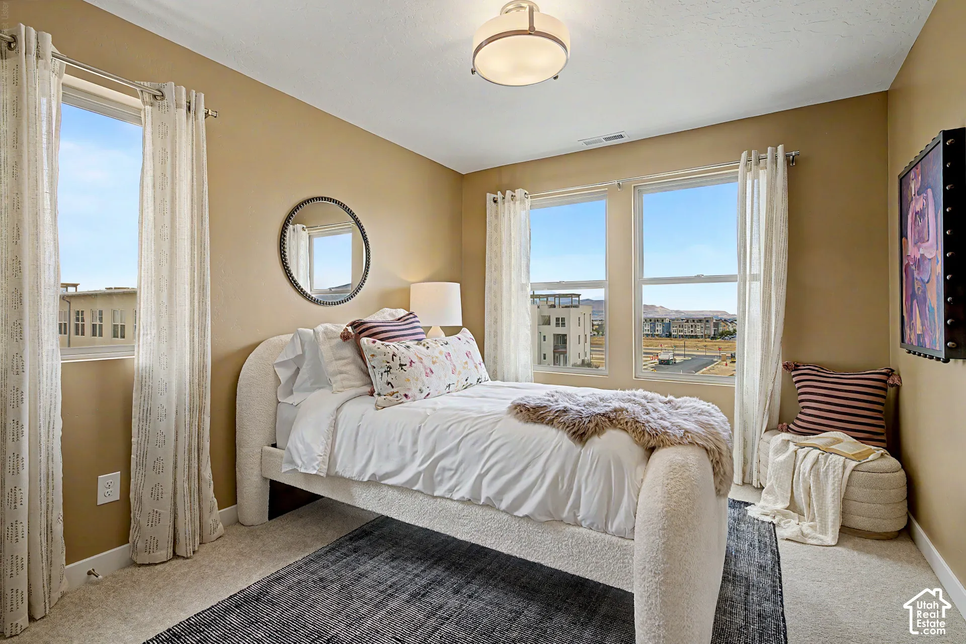 Recessed lighting, wall-to-wall carpeting, and multiple windows with roller shades