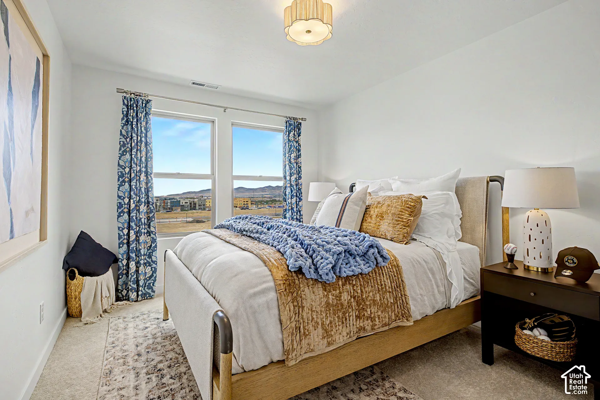 Bedroom featuring two large windows, neutral carpet flooring, and a decorative ceiling light fixture