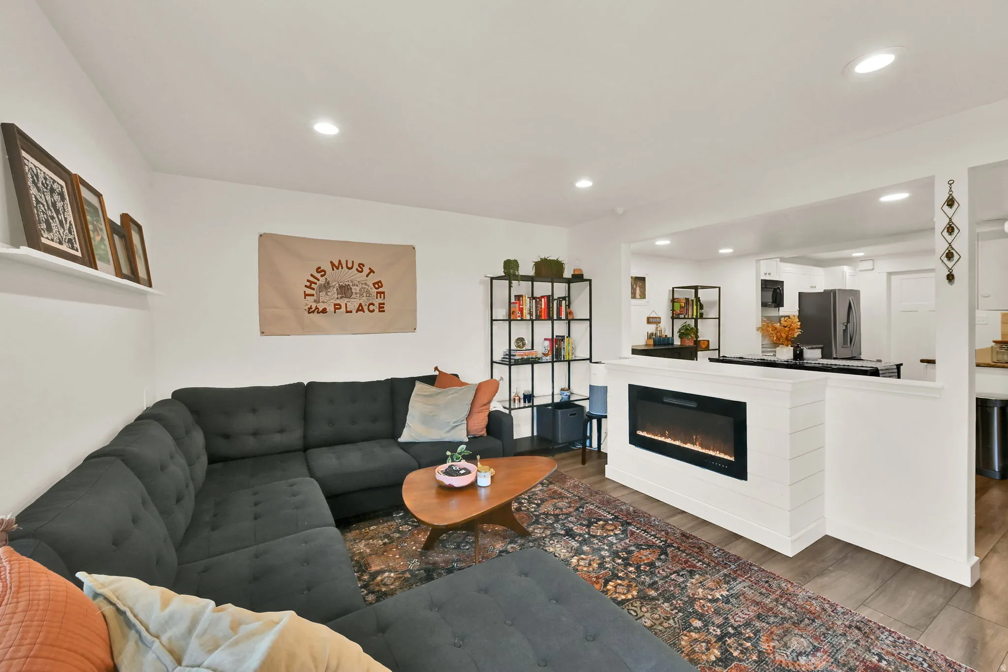 Wood-finish flooring throughout, recessed lighting, and a built-in electric fireplace