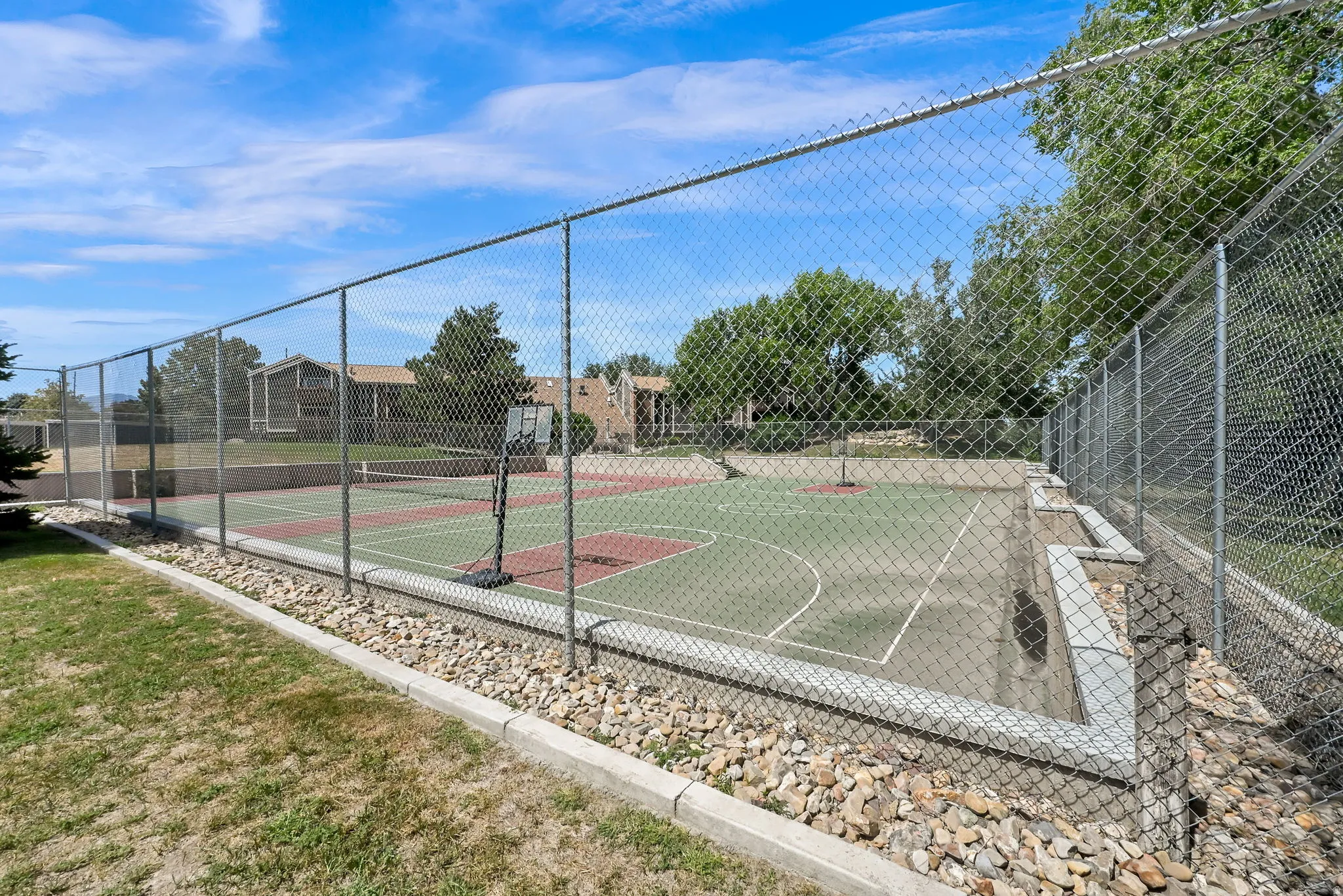 Fenced multi-sport court with a tennis court and basketball area