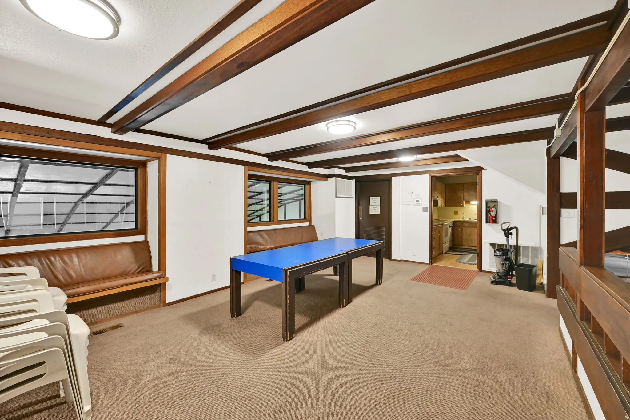 Exposed wood beam ceiling detail, built-in wooden bench seating, and recessed lighting fixtures