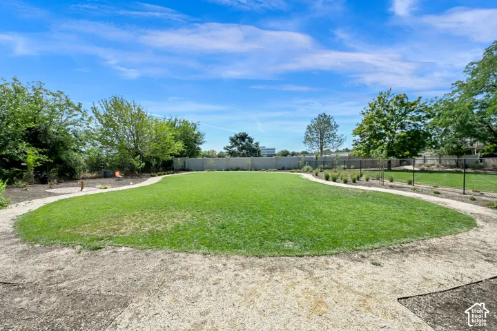 Expansive grassy area with a curvilinear gravel pathway and perimeter landscaping