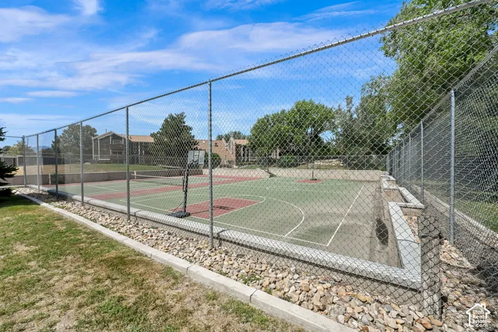 Fenced multi-sport court with a tennis court and basketball area