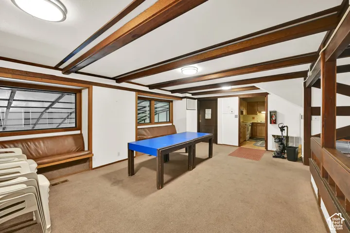 Exposed wood beam ceiling detail, built-in wooden bench seating, and recessed lighting fixtures