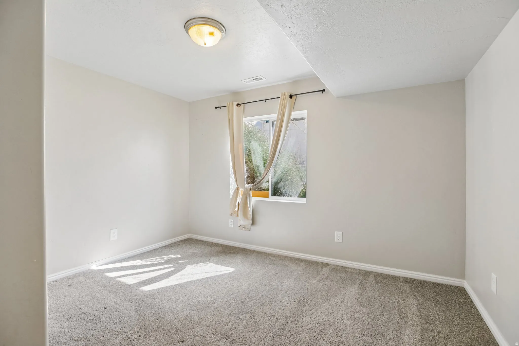 Neutral-toned walls complement plush carpeting