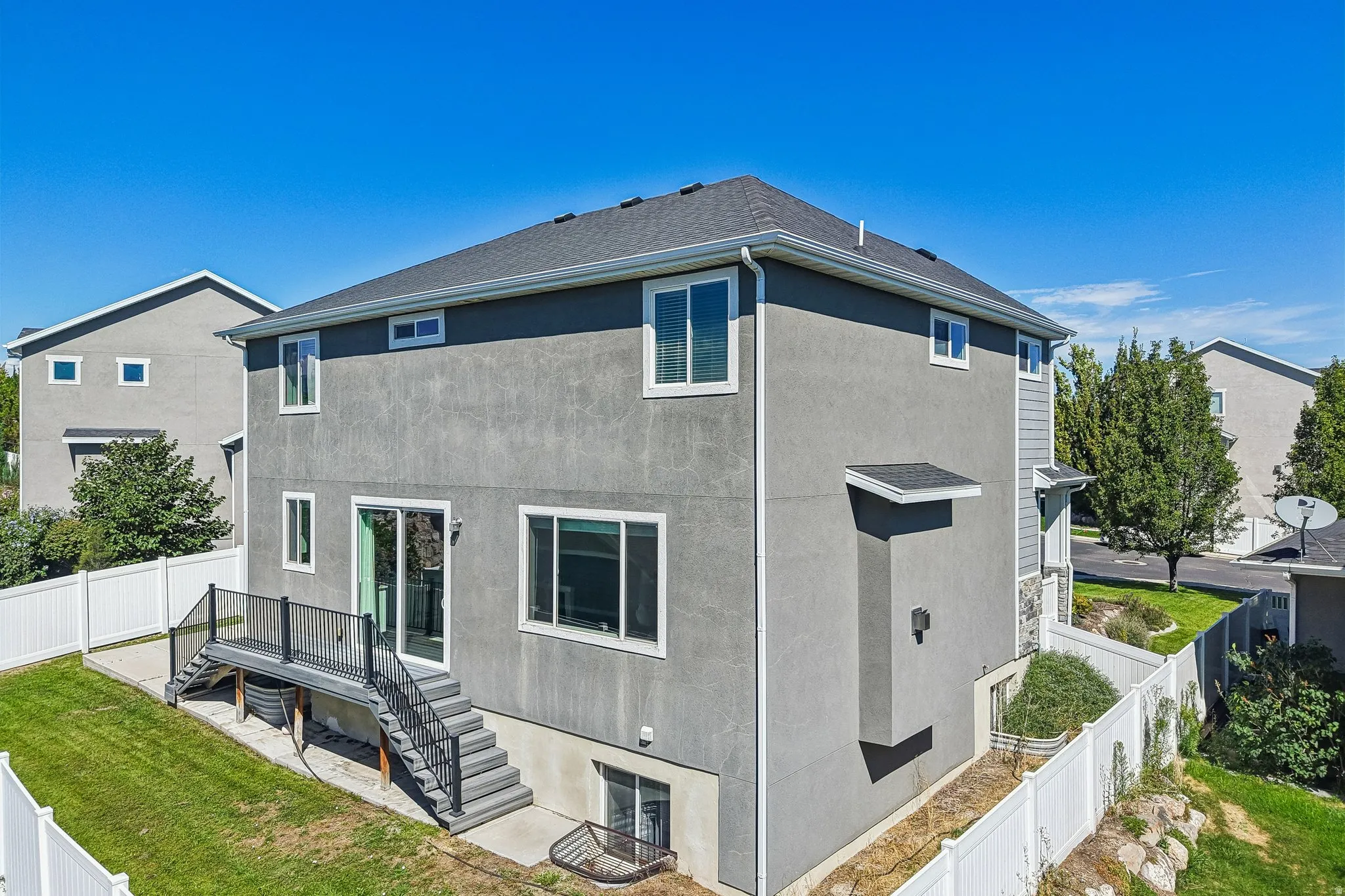 Gray stucco exterior with white trim windows