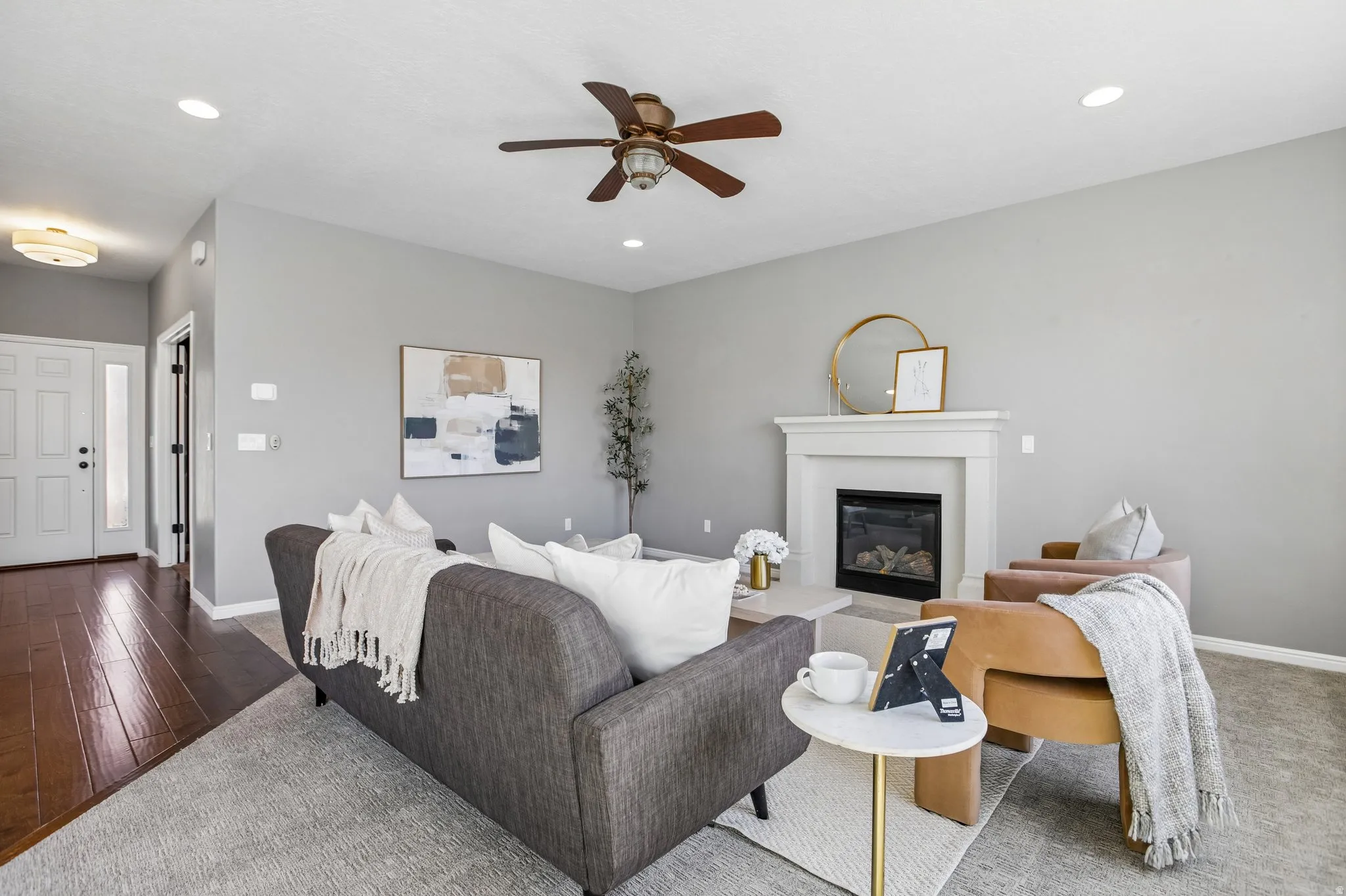 Living area featuring a fireplace with a white mantel, recessed lighting, and a ceiling fan