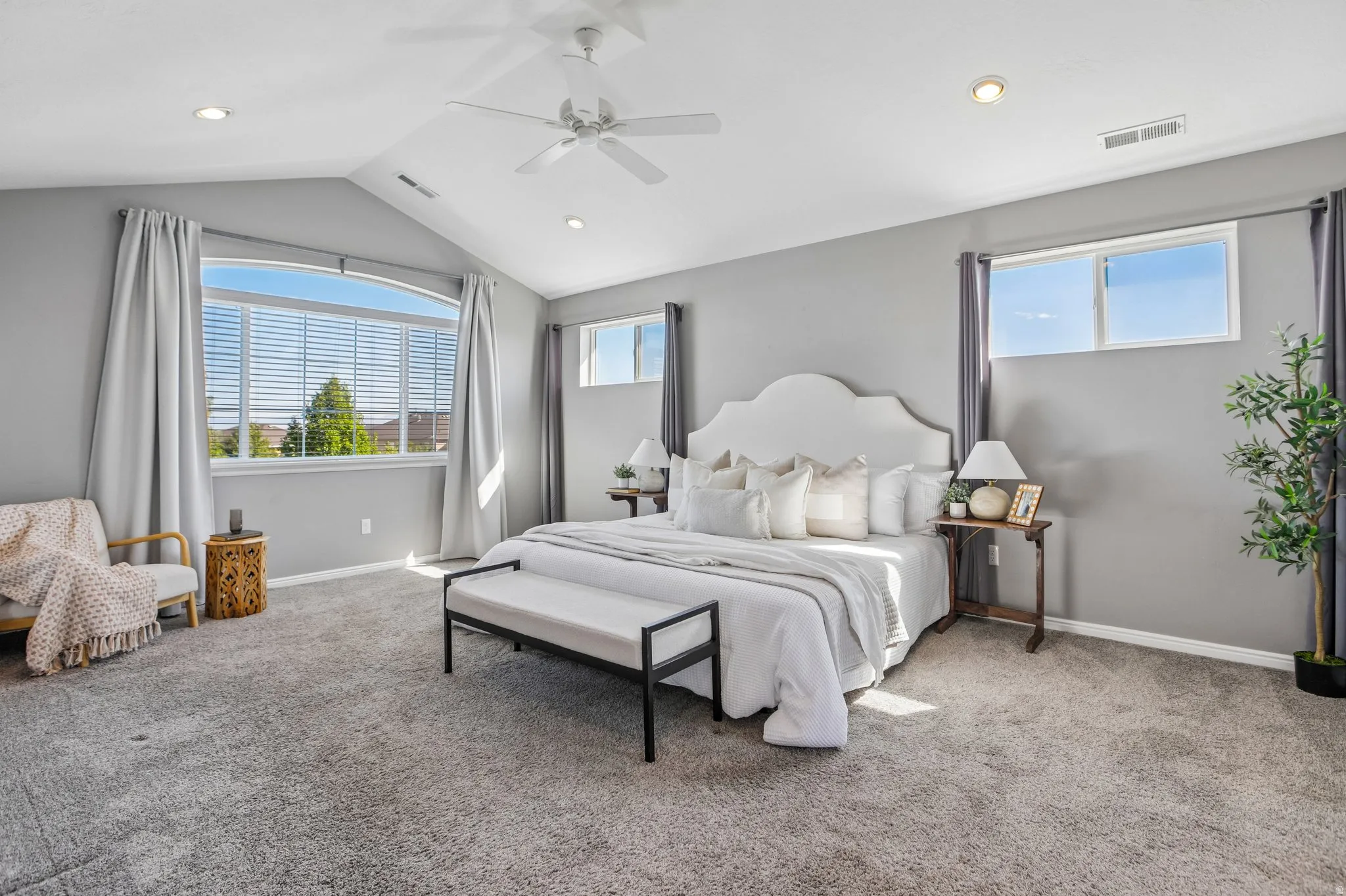 Vaulted ceiling with a ceiling fan, recessed lighting, and expansive windows
