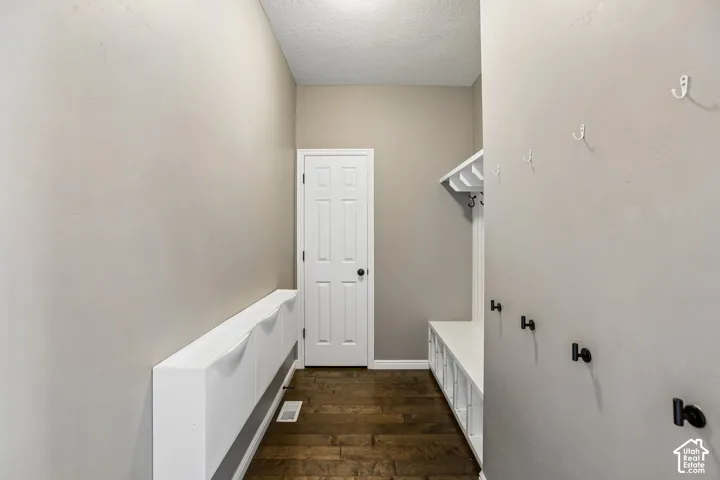 Built-in storage bench with cubbies, wood-finish flooring, and a paneled door