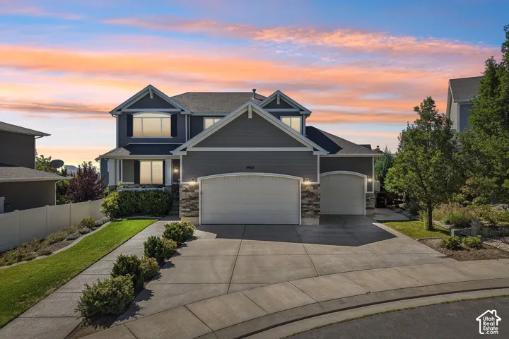 Two-story residence featuring a two-car garage, stone accents, and a concrete driveway
