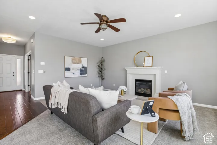 Living area featuring a fireplace with a white mantel, recessed lighting, and a ceiling fan