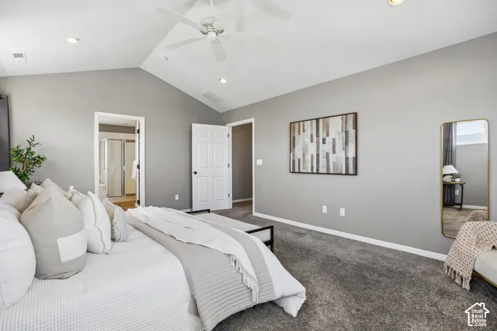 Vaulted ceilings with a ceiling fan and recessed lighting, plush carpeting, and a visible doorway to a bathroom featuring a glass-enclosed shower