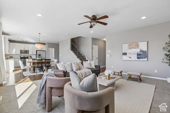Open-concept living space with recessed lighting, wood-finish flooring, and a modern staircase with metal railings