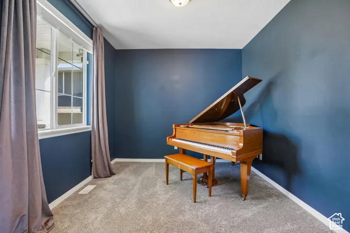 Carpeted room with blue walls, a white window frame, and white trim