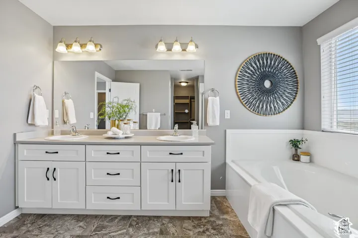 Double vanity with white cabinetry, light-toned countertop, and dual undermount sinks