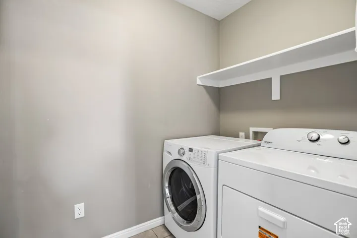 Dedicated laundry area featuring a built-in white shelf and tile flooring