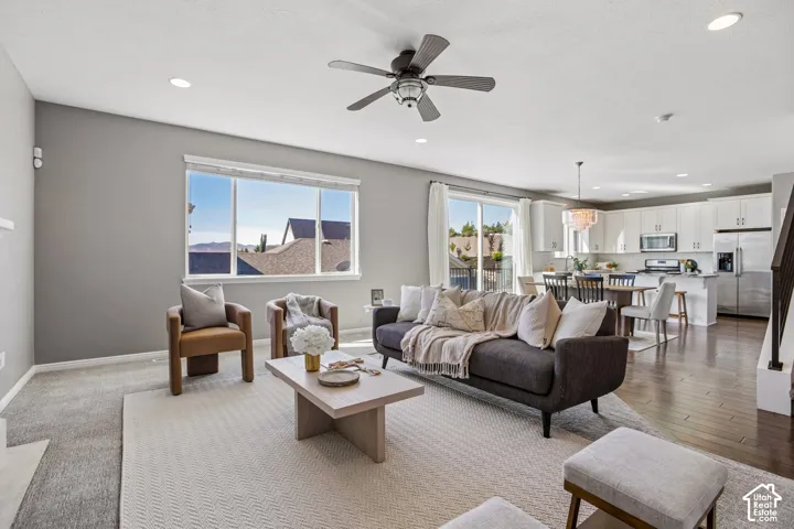 Open-concept living area featuring a ceiling fan, recessed lighting, and large windows