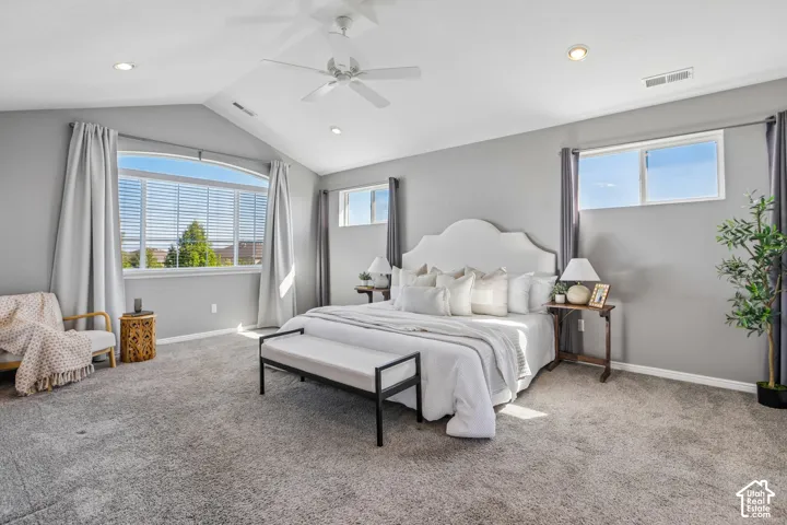 Vaulted ceiling with a ceiling fan, recessed lighting, and expansive windows
