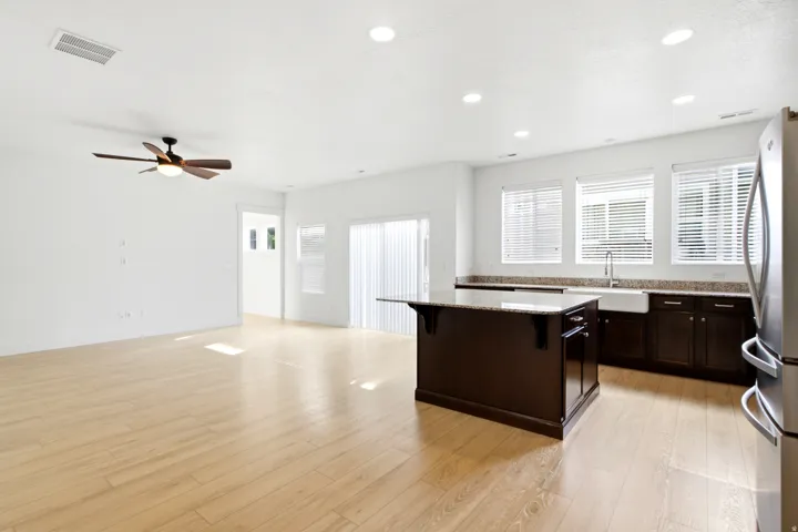 Open-concept living space featuring light wood-finish flooring, recessed lighting, and a ceiling fan