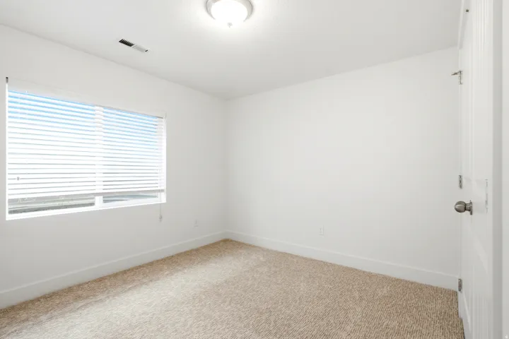 Carpeted flooring, white walls, horizontal window blinds, and a semi-flush mount ceiling light