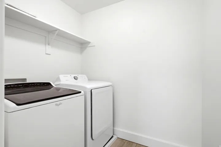 White laundry appliances with a top-load washing machine and a front-load dryer
