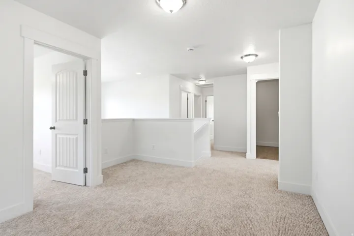 Neutral-toned carpet flooring and white walls