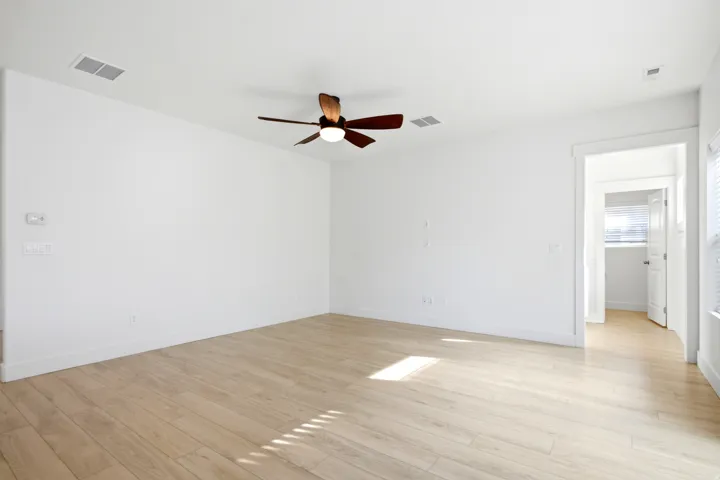 Wood-finish flooring, ceiling fan with integrated lighting, recessed lighting, and white trim