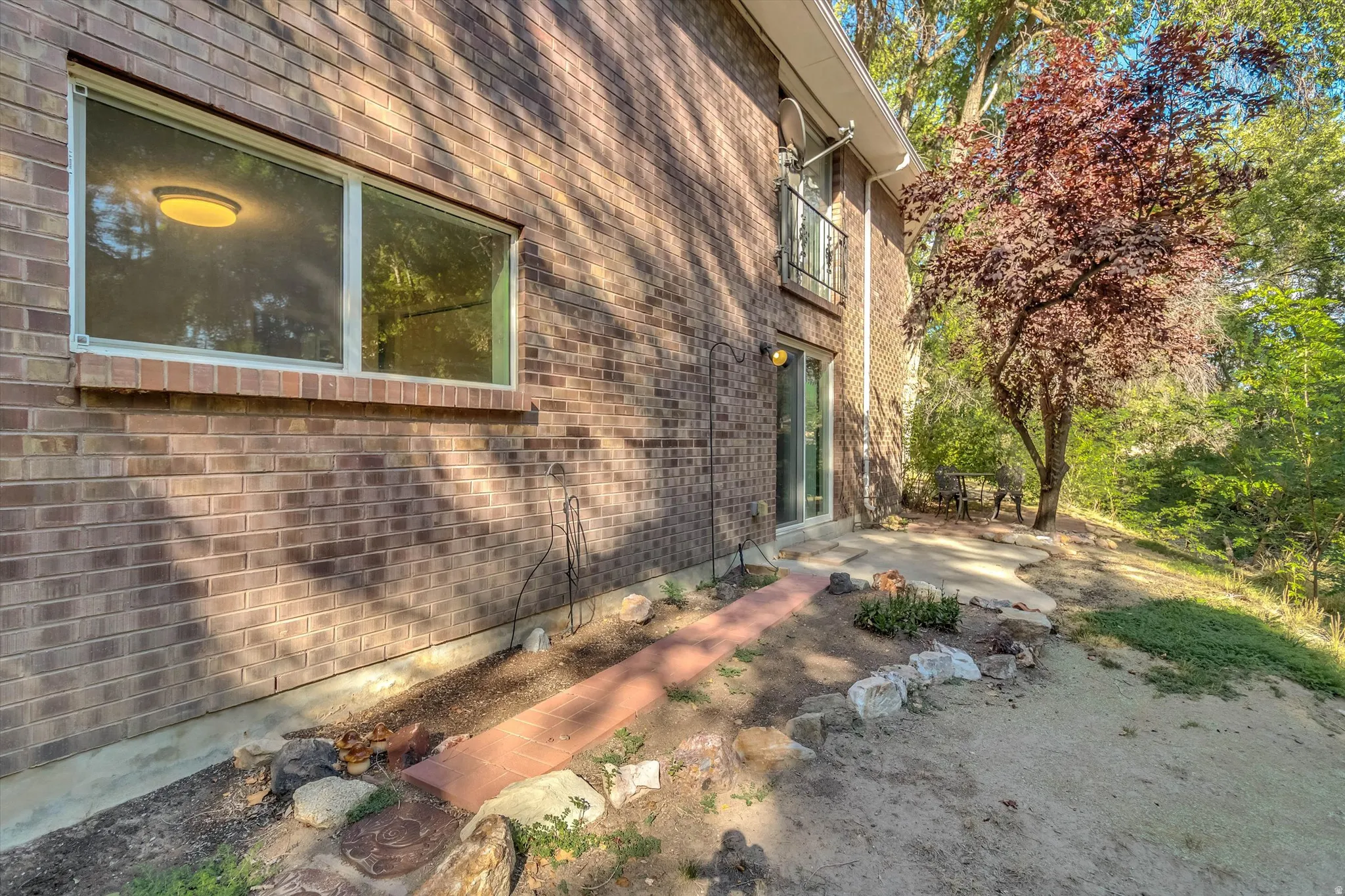 Brick exterior with a ground-level window and sliding glass door