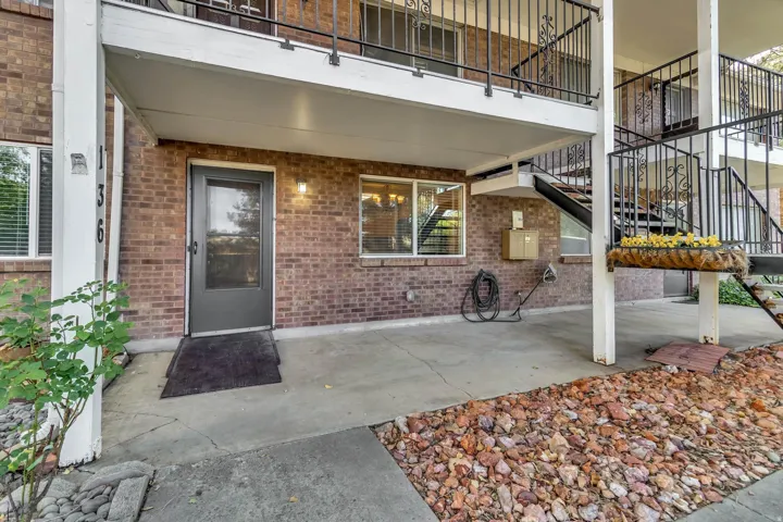 Brick exterior with a covered entry, concrete patio, and dark-framed windows