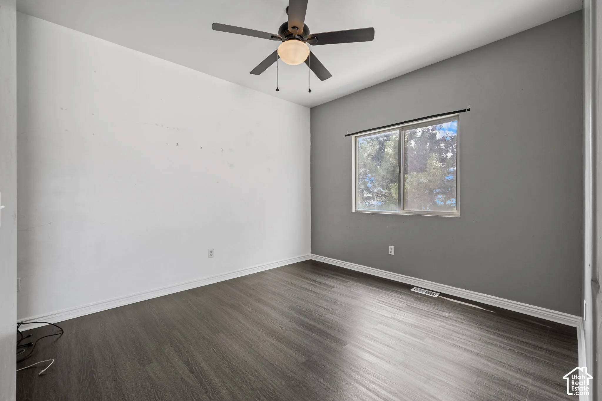Wood-finish flooring, ceiling fan with integrated lighting, dual-pane window, and painted walls