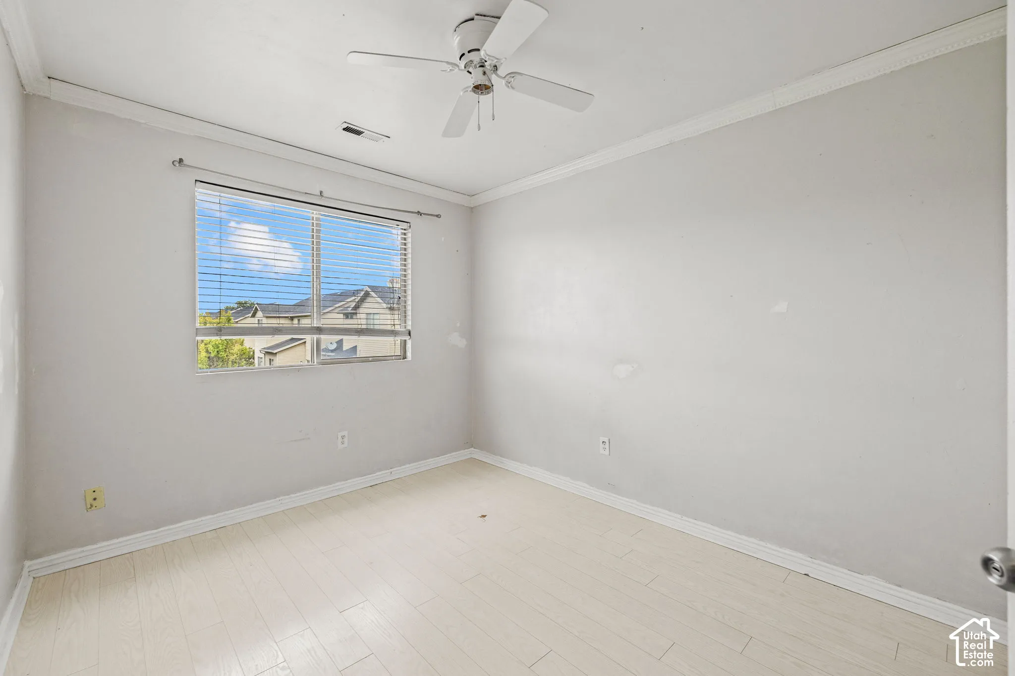 Recessed window with blinds, wood-finish flooring, ceiling fan, and crown molding