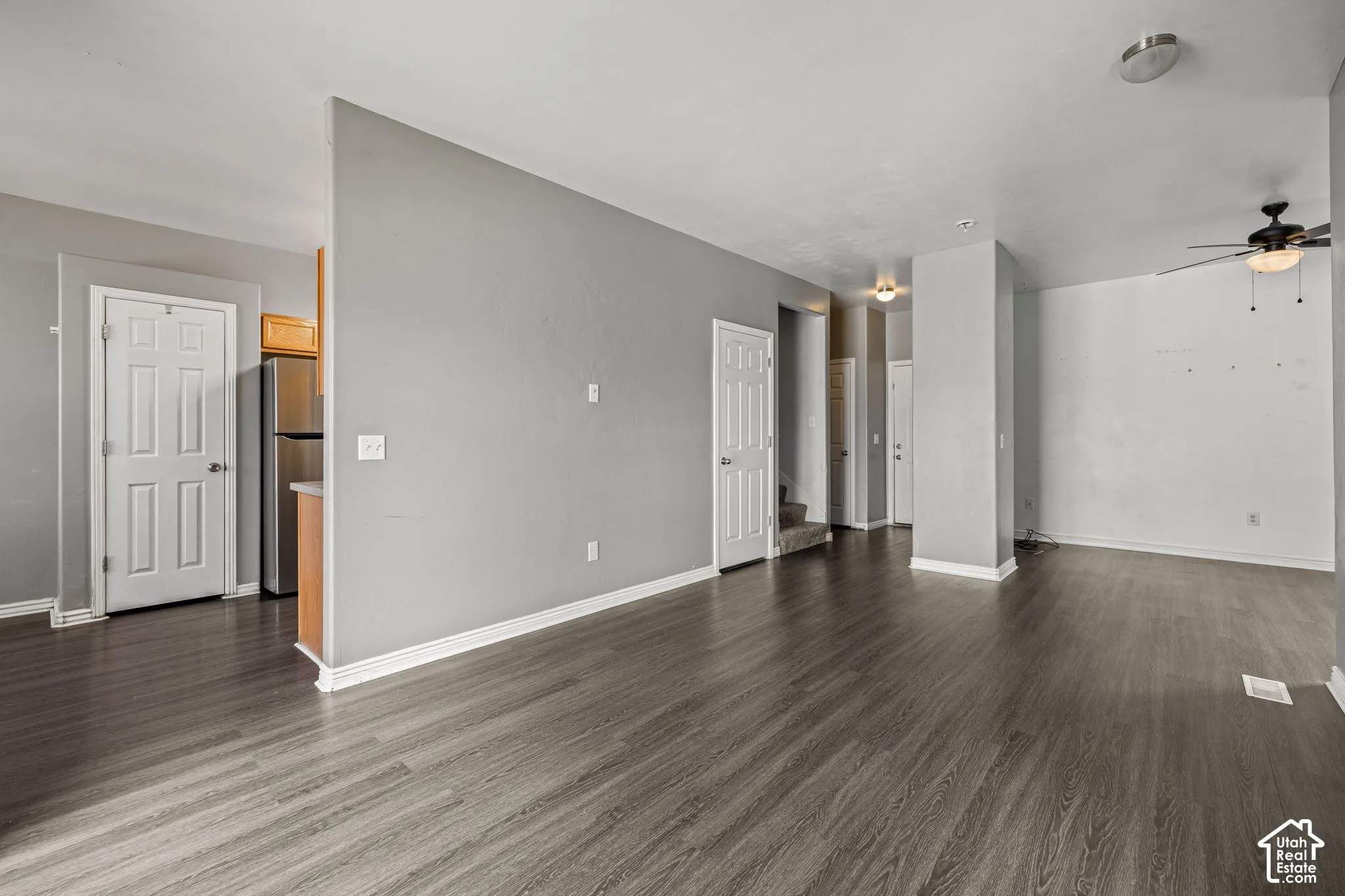 Wood-finish flooring, recessed lighting, ceiling fan, and white trim