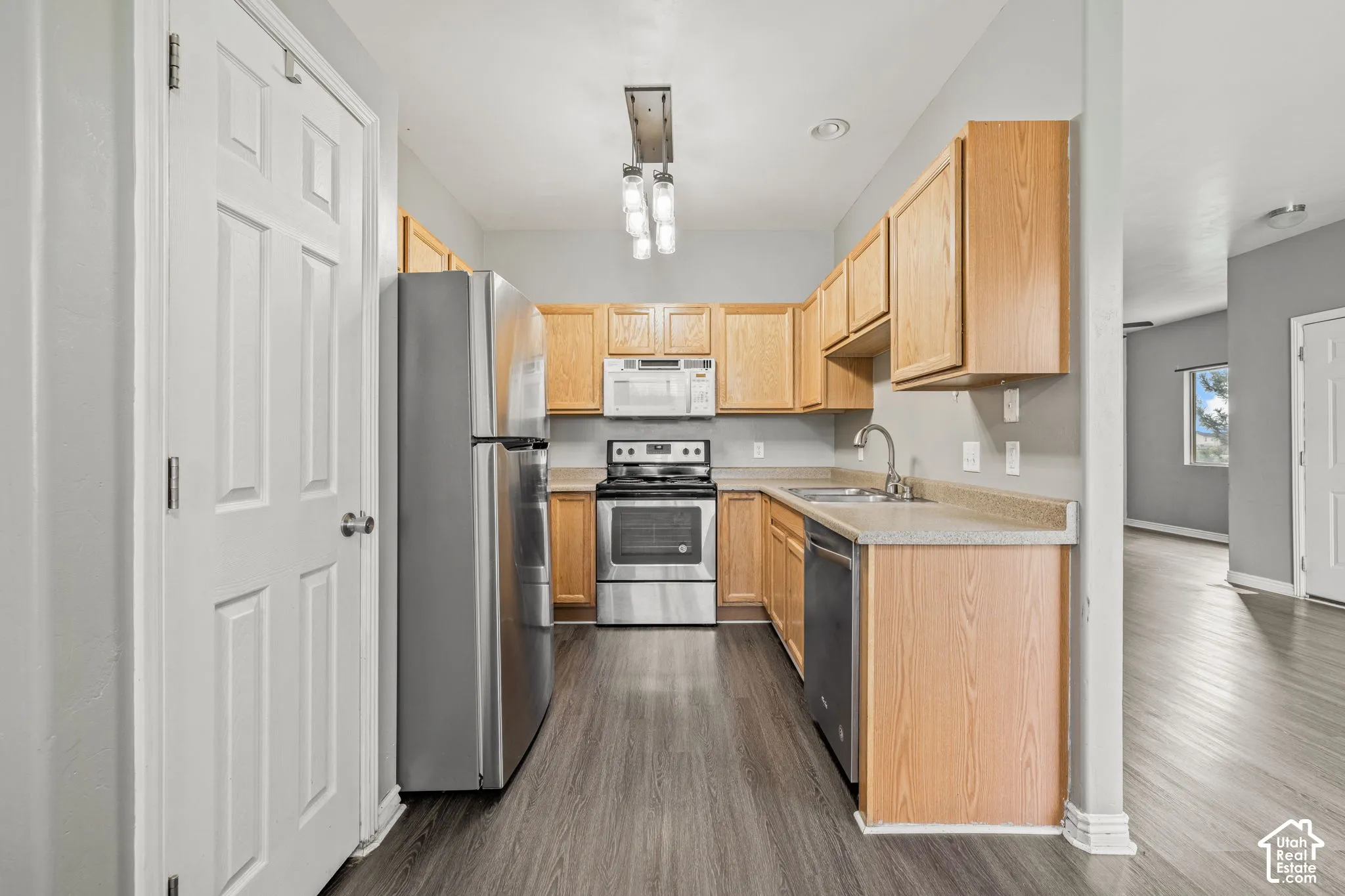 Kitchen featuring wood-finish cabinetry, stainless steel appliances, and wood-finish flooring
