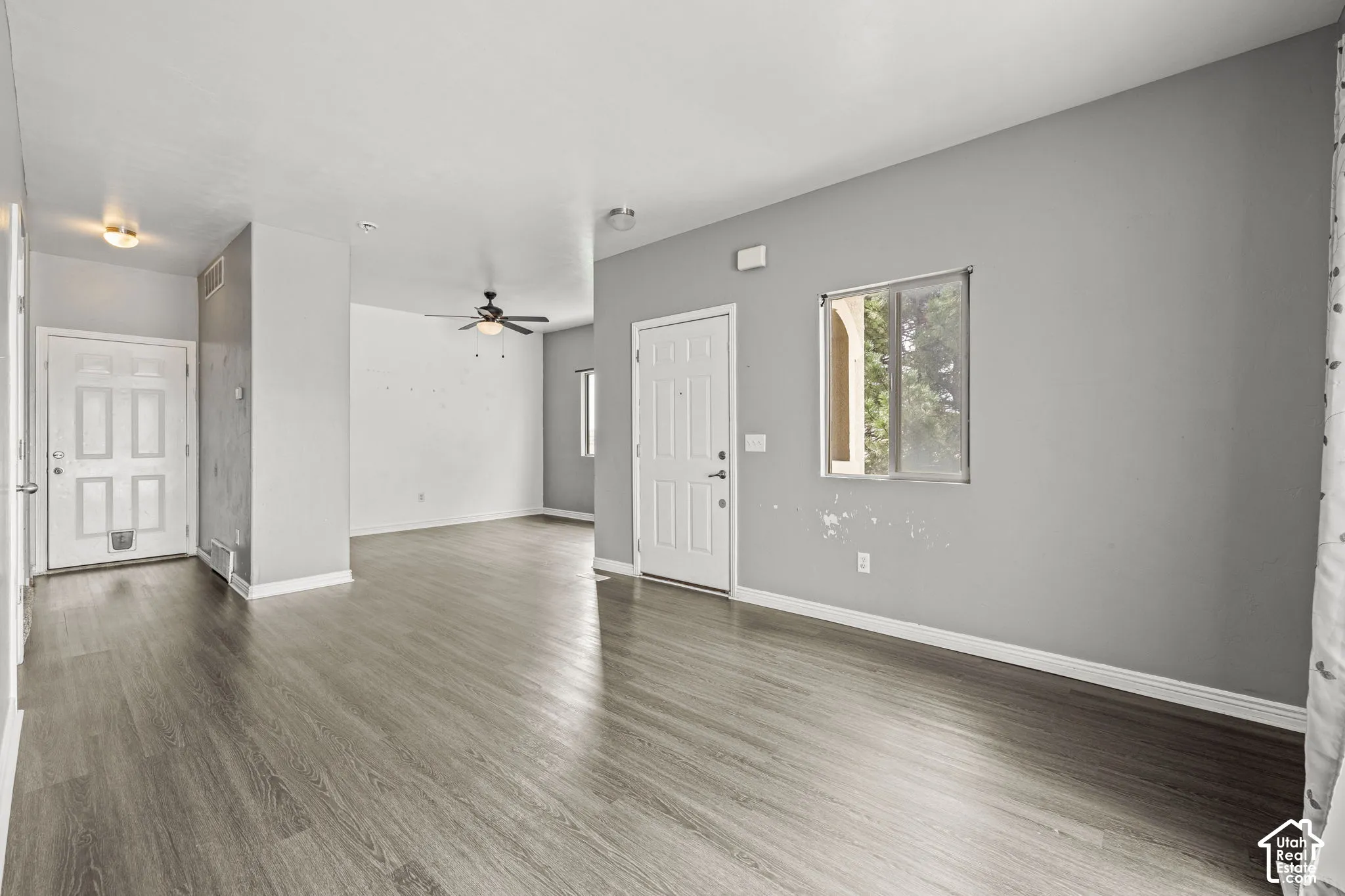 Wood-finish flooring throughout, ceiling fan, and window with natural light