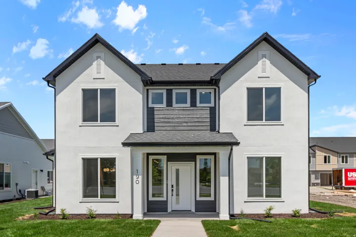 Contemporary exterior featuring white stucco and dark siding accents