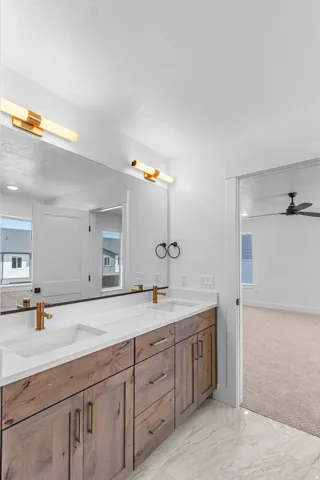 Dual vanity with wood-finish cabinetry, white countertops, and undermount sinks