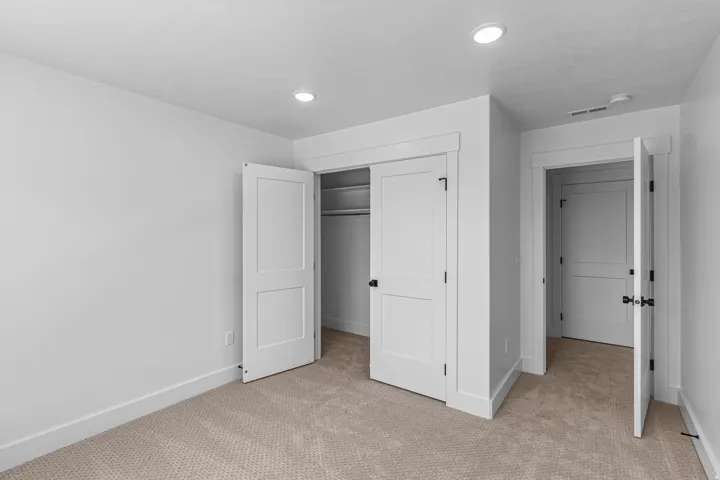Recessed ceiling lighting, paneled interior doors, closet with built-in shelving, carpeted flooring, and white trim