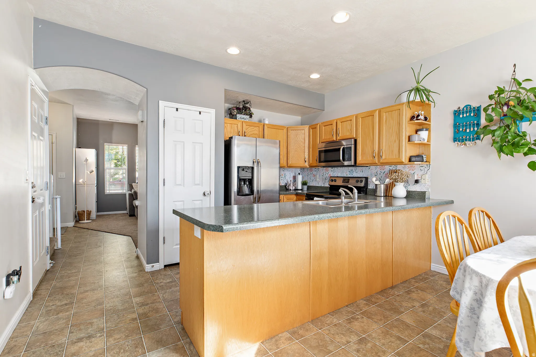 The good-sized kitchen offers ample counter and cabinet space, a pantry, spacious dining area, and a convenient peninsula breakfast bar with seating for four
