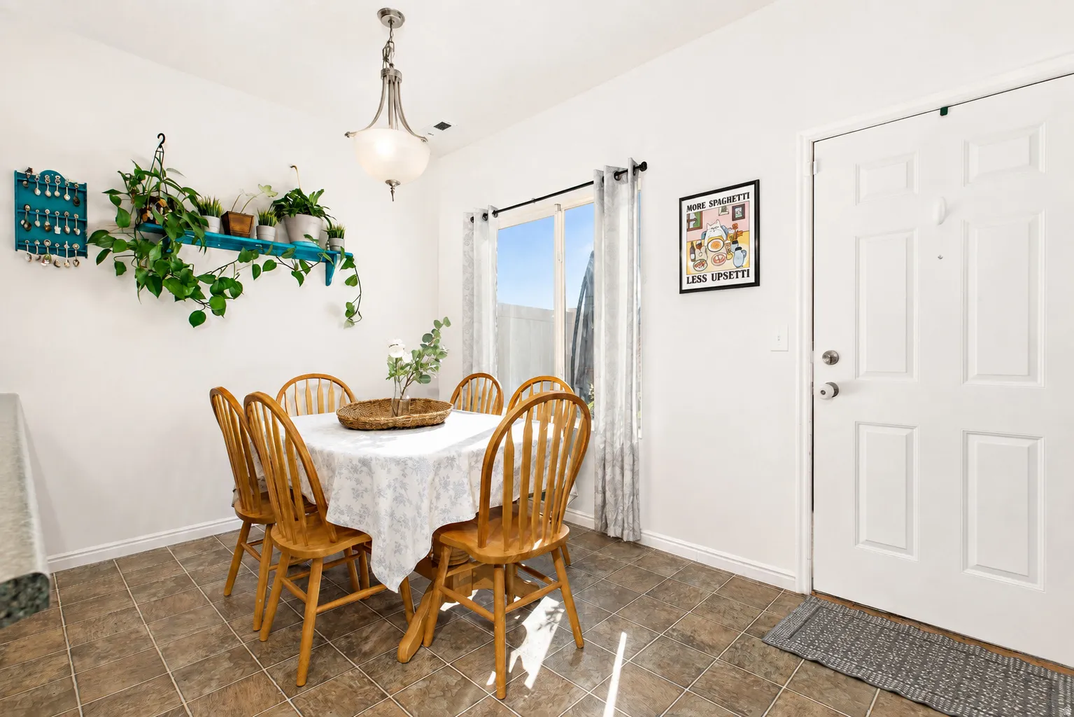 Roomy dining area bathed in natural light with door leading to private outdoor patio