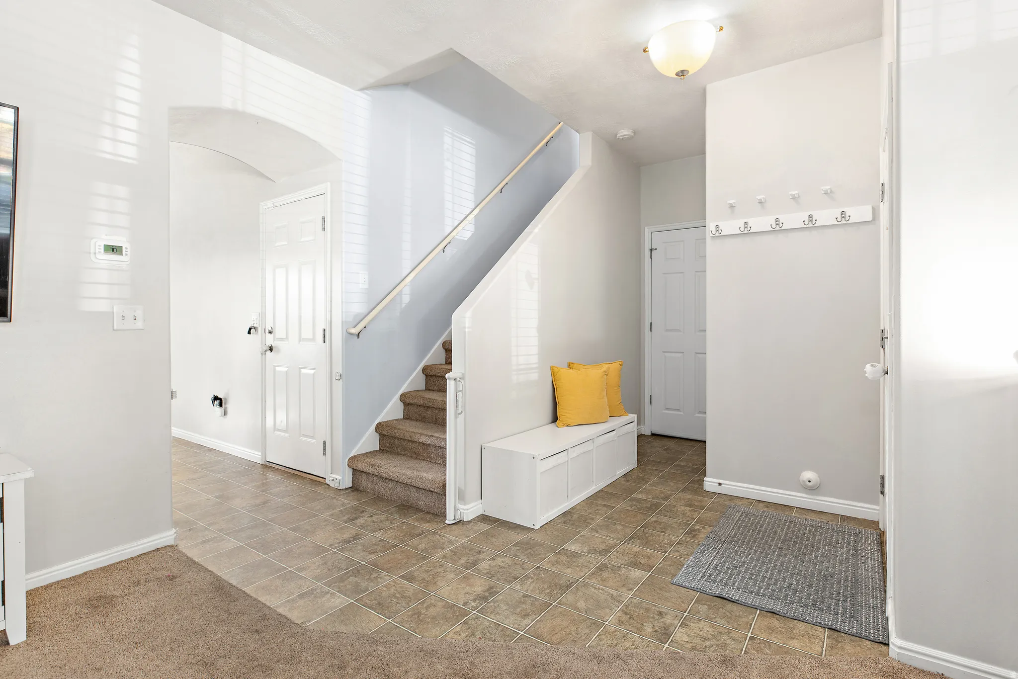 Roomy entry with shoe bench, coat rack and stairs