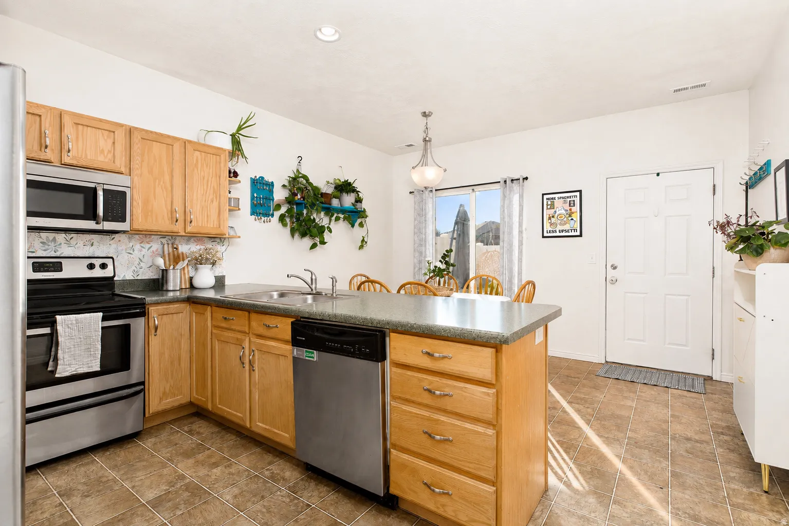 The good-sized kitchen offers ample counter and cabinet space, a pantry, spacious dining area, and a convenient peninsula breakfast bar with seating for four
