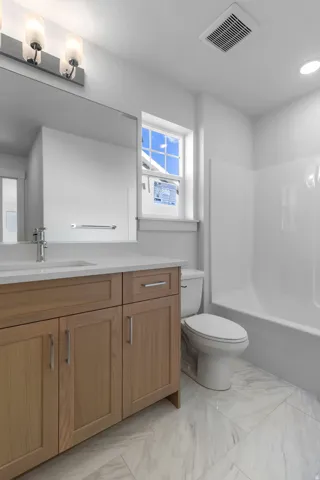 Light wood-finish vanity with a white countertop and rectangular undermount sink