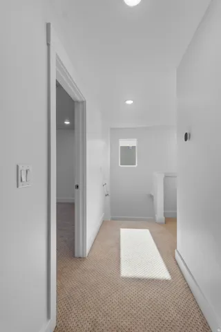 Recessed ceiling lighting, neutral carpeting, window with natural light, white wall finishes, and modern light switches