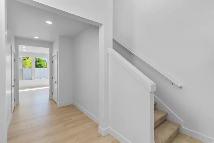 Entryway featuring recessed lighting, wood-finish flooring, and a staircase with carpeted treads