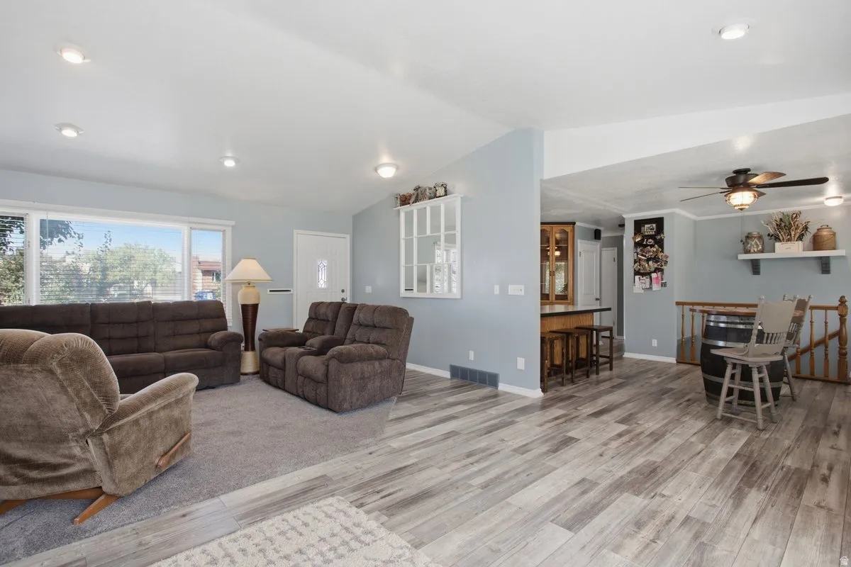 Open concept living space featuring wood-finish flooring, recessed lighting, and bar seating