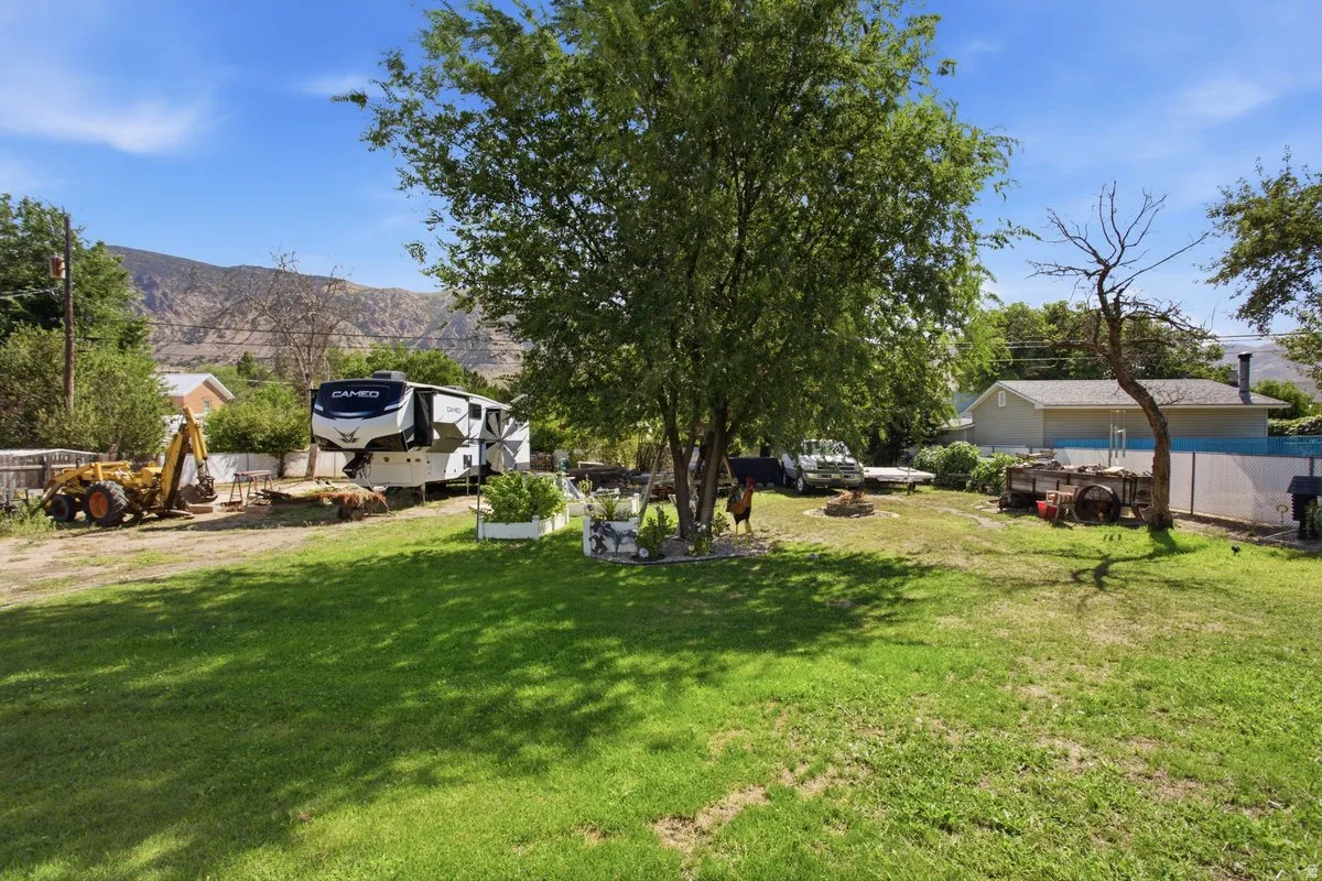.43 acres of grassed yard space featuring mature trees and mountain backdrop. Plenty of room for your Big Boy/Girl toys!