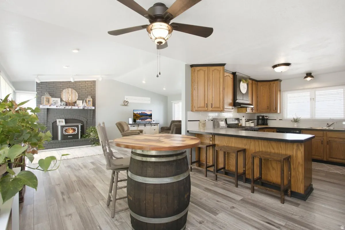Open-concept kitchen with wood cabinetry and a peninsula breakfast bar