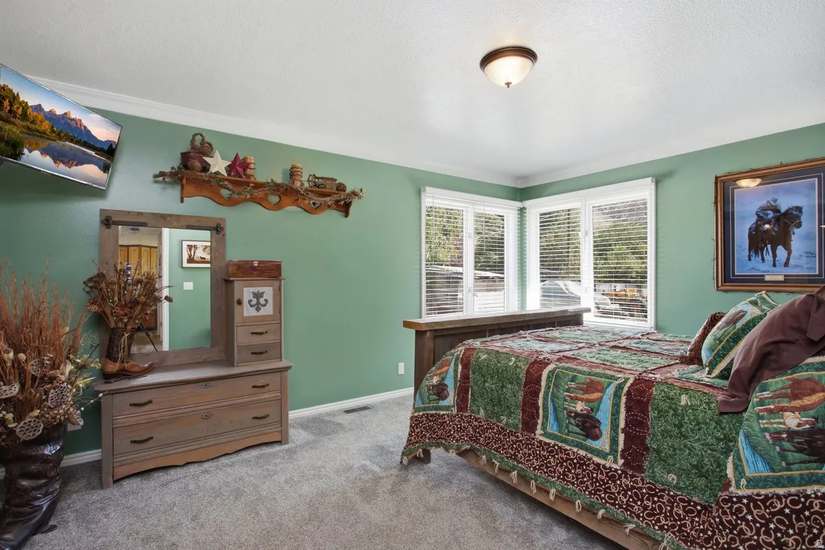 Corner window configuration with horizontal blinds, overhead ceiling light fixture, and crown molding